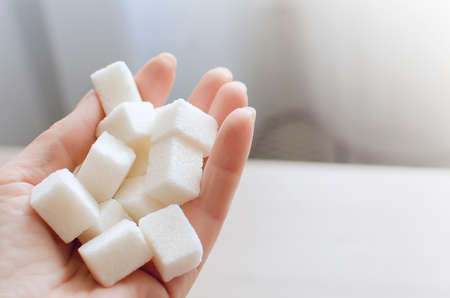 close up of White sugar cubes in the hand. The concept of unhealthy eating.の写真素材