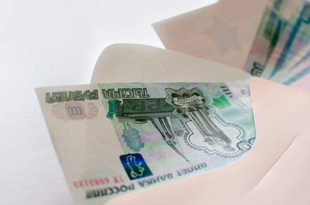 On the table is a gift envelope with Russian banknotes in denominations of one thousand rubles. The...