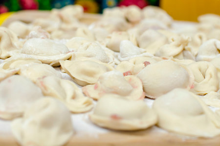 Process of making homemade raw pastry dumplings with meat filling on a wooden Board. Pelmeni. A traditional dish of Russian cuisine. selective focusの写真素材