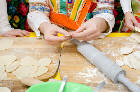 Children's hands make dumplings. Master class on making dumplings. Close-up, selective focus.の写真素材