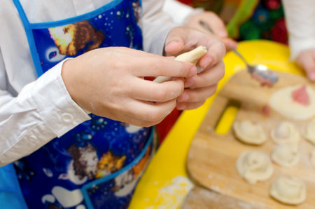 Close-up of hands putting filling into dough to make dumplings.の写真素材