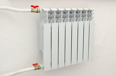 white heating radiator hanging on the wall in the living room, close-upの写真素材