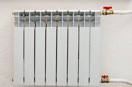A white heating radiator hangs on the wall.の写真素材
