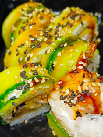 High angle of assorted sushi rolls on wooden platter with soy sauce.の写真素材