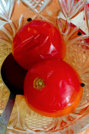 Pickled tomatoes with dill, garlic, spices in a bowl. Close-up, selective focus.の写真素材