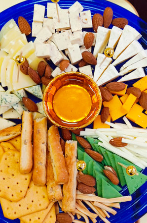 View from above Close-up of a plate with Various types of cheese, nuts, honey. Close-up, vertical photograph.の写真素材