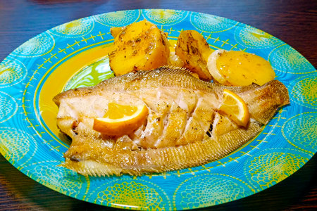 Tasty healthy food concept. Baked flounder fish with potatoes on a plate.の写真素材