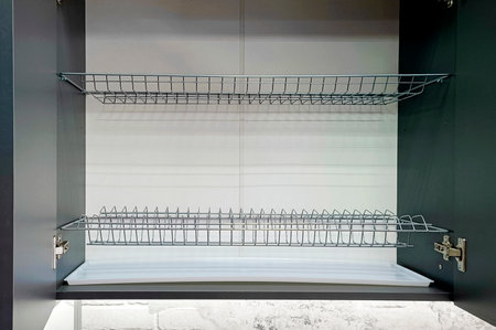 Close-up of a dish drainer in a kitchen cabinet.の写真素材