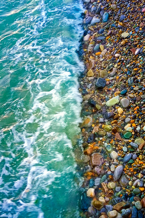 Beautiful summer sea background. Sea turquoise wave washes the pebble shore. Vertical photo.の写真素材
