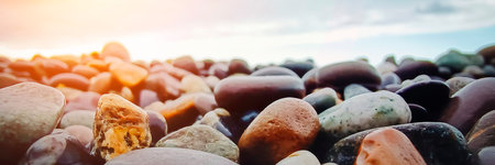 Large multicolored sea stones pebbles against blue sea background. Beautiful natural panoramic background.の写真素材
