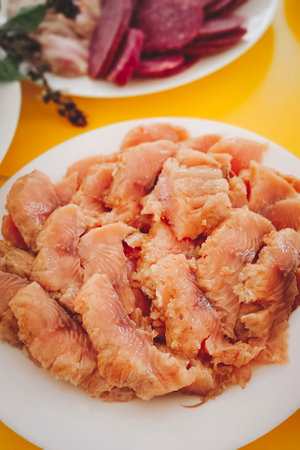 Pieces of lightly salted red fish lie on a plate. Close-up, vertical photo.の写真素材