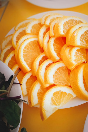 Sliced orange on a plate. Close-up, vertical photo.の写真素材