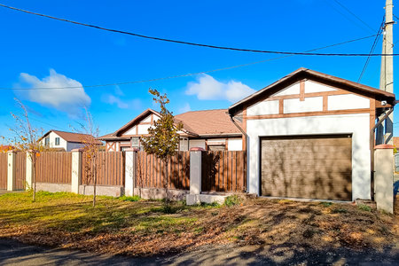 Beautiful half-timbered country house with a garage and a brown wooden fence.の写真素材