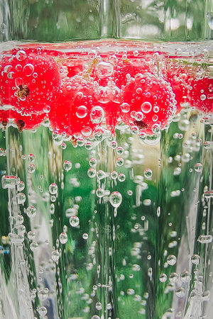 Red currents in a glass of sparkling mineral water. Non-alcoholic healthy drink.の写真素材