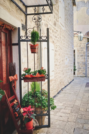 Old street with ancient architecture. The entrance to the house is decorated with flowers.の写真素材