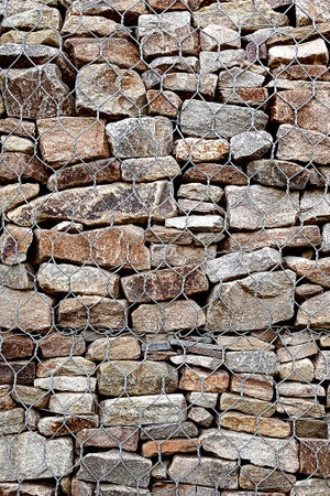 Gabion mesh and stones background wallpaper. Close-up, vertical photo.の写真素材
