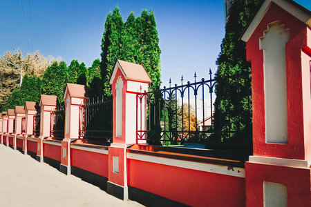 Forged metal fence with colored concrete pillars. Retro design.の写真素材