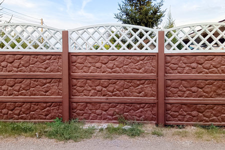 A concrete fence close-up painted with brown and white paint.