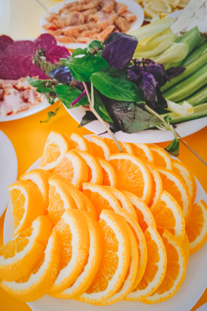 orange slices on a plate next to other food.の写真素材