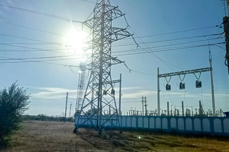 Electricity transmission towers and lines on the street in the light of the setting sun.の写真素材