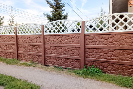 A country house enclosed by a concrete fence painted brown and white, in a vintage style.の写真素材