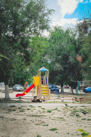 Saratov, RUSSIA - September 20, 2024: Children's amusement slide on a playground among trees in a residential area of the city. Vertical photo.の写真素材