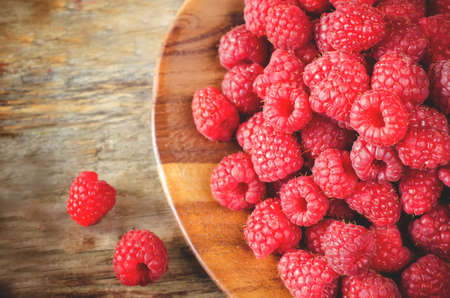 raspberry on a dark wood background. toning. selective focus on the right middle raspberries.の写真素材