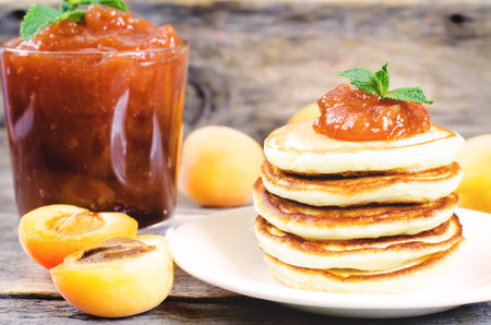 pancakes with apricot jam on a dark wood backgroundの写真素材
