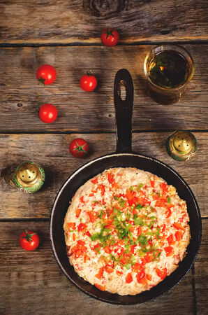 traditional turkish omelet menemen with tomatoes on the dark wood background.の写真素材