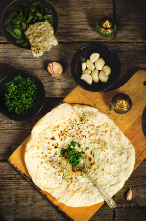 arabian bread with herbs on a dark wood background. toning. selective focus on the dillの写真素材