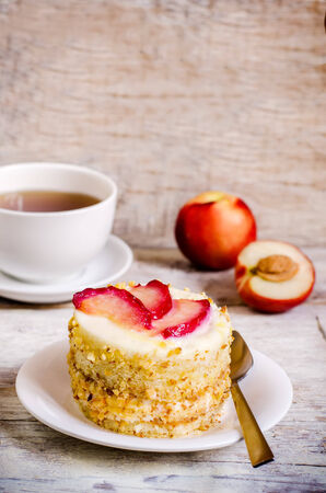 cheesecake mini with peaches on a white wood background. toning. selective focus on slices of  peaches on the cheesecakeの写真素材