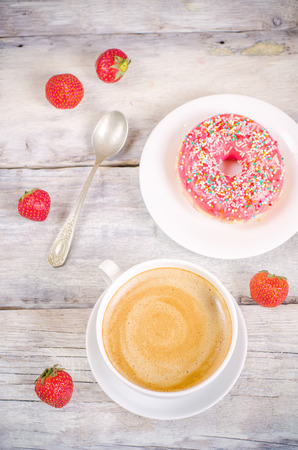 Donuts and coffee on a white wood background. toning. selective focus on coffeeの写真素材