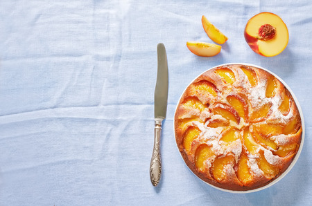 cake with peaches on a blue background. toning. selective focus on the middle of the pieの写真素材