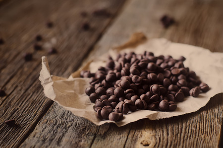chocolate chips on a dark wood backgroundの写真素材