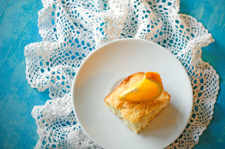 orange cake on a white plate on a blue backgroundの写真素材