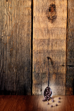 chocolate chips on a dark wood background. toning. focus on chocolate drops in a spoonの写真素材