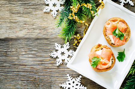 profiteroles with salmon and cream cheese on a dark wood background. tinting. selective focus on parsley on the top profiteroleの写真素材
