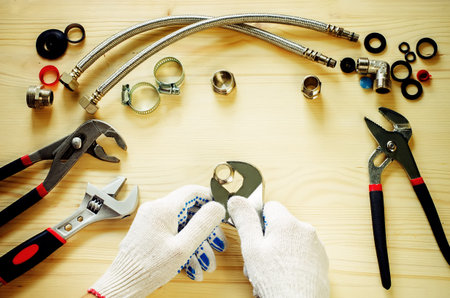 plumber at work with tools plumbing on a light woody background. tinting. selective focus on the...
