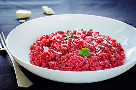 risotto with beetroom on a dark wood background. tinting. selective focus on parsleyの写真素材