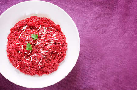 risotto with beetroom on a purple wood background. tinting. selective focus on parsleyの写真素材