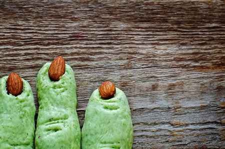 Halloween witch's fingers cookies on a dark wood background. tinting. selective focus on a middle biscuitsの写真素材