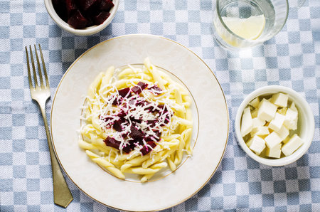 pasta with roasted beets and goat cheese on a light background. tinting. selective focus on the middle pastaの写真素材