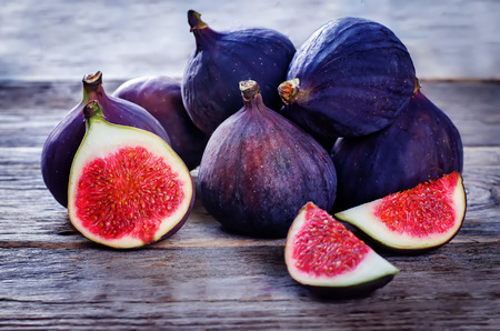 figs on a dark wood background. tinting. selective focus on the left figs sliceの写真素材