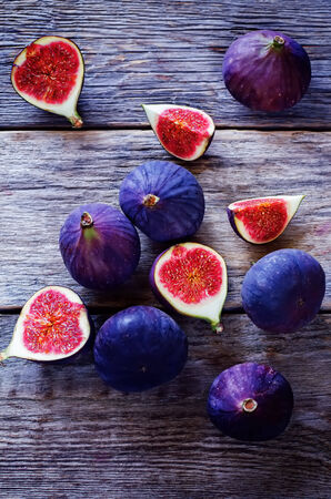figs on a dark wood background. tinting. selective focus on the middle figs sliceの写真素材