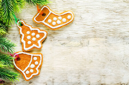 ginger biscuits and a branches of a Christmas tree on a white wood background. tinting. selective focusの写真素材