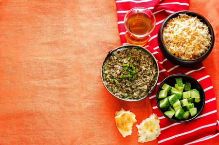 minced lamb, cooked with spinach on a orange background. tinting. selective focus on green onionsの写真素材