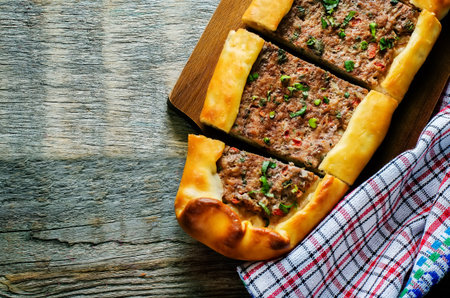 traditional Turkish pastries with meat on a dark wood background. pide. tinting. selective focus on...