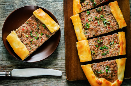 traditional Turkish pastries with meat on a dark wood background. pide. tinting. selective focus on a piece of pideの写真素材