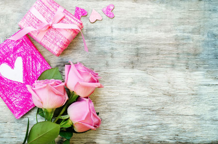Valentine's background with gift, flower and card on a white wood background. tinting. selective focus on cardの写真素材