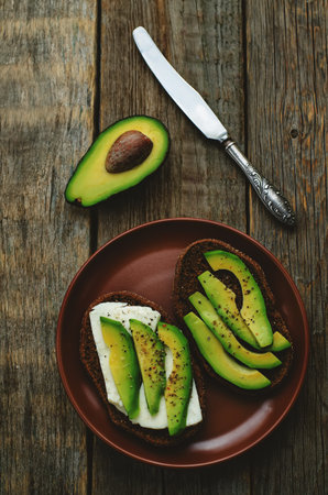 sandwich of rye bread with avocado and goat cheese.